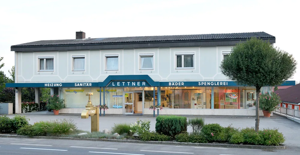 Firmengebäude in der Linzerstraße 63 mit dem Schriftzug Heizung, Sanitär, Lettner, Bäder, Spenglerei und dem goldenen Wasserhahn davor